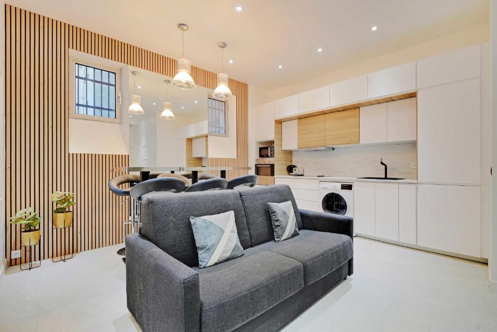un salon avec un canapé et une cuisine dans l'établissement Cosy apartment - 2BR-6P - Haut Marais, à Paris