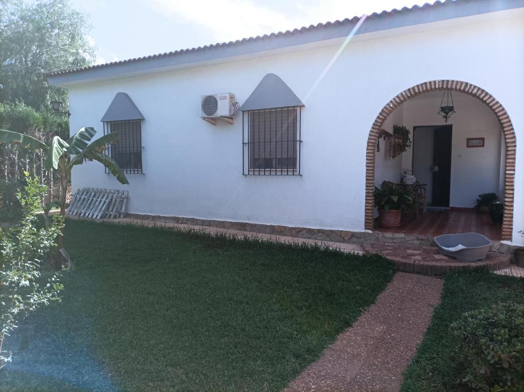 una casa blanca con un arco y un patio en El Torreon Vacacional, en Mairena del Alcor