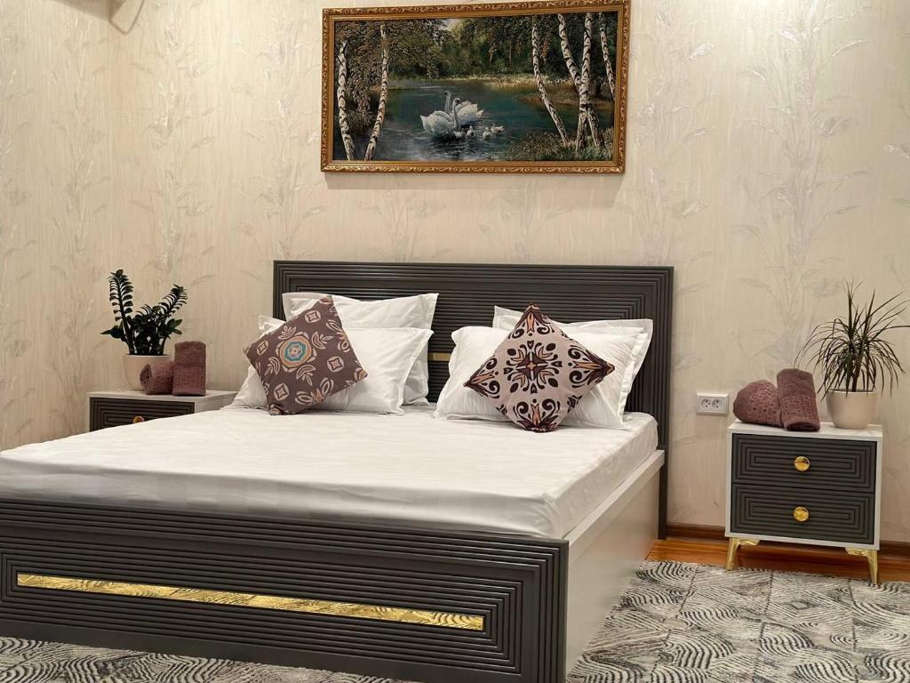 um quarto com uma cama grande com almofadas em VILLA ANOR em Yakkasaray