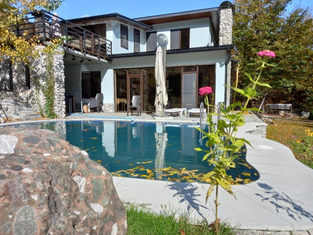 a swimming pool in front of a house at Istisu Valley Spa in İsmayıllı