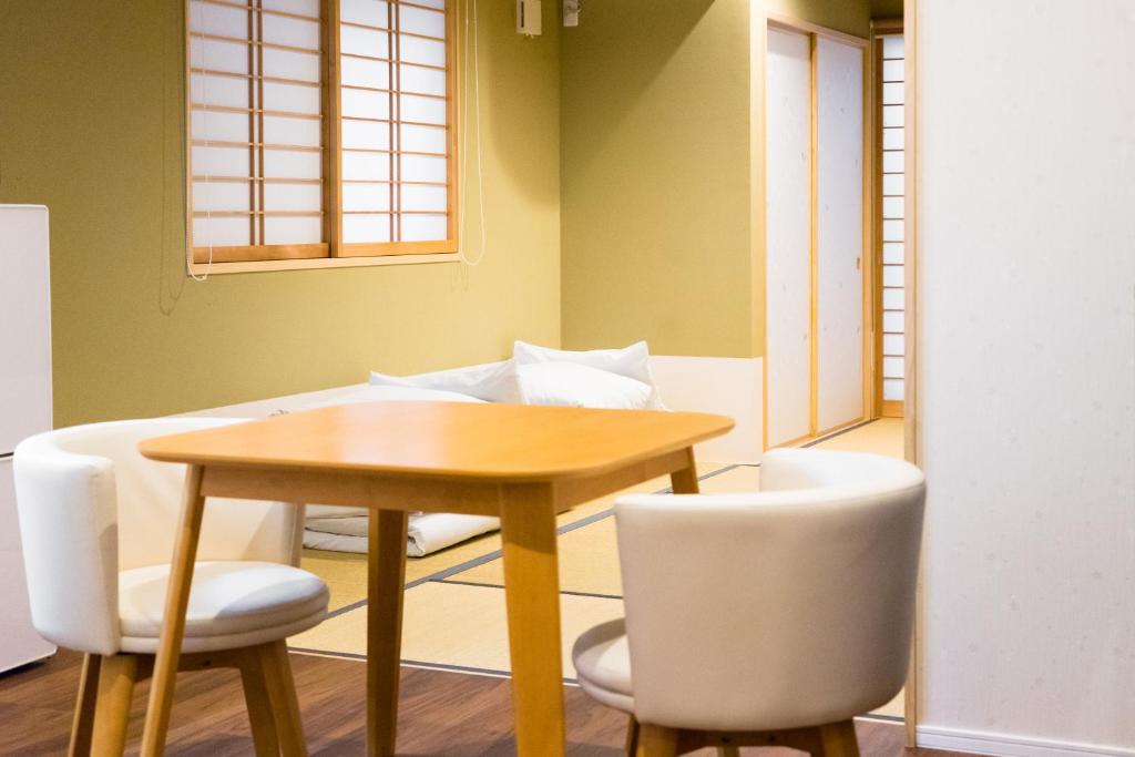 a dining room with a table and chairs at Guesthouse ZenNichi in Kyoto
