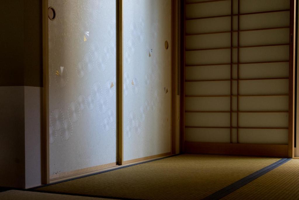 an empty room with an open sliding door at Guesthouse ZenNichi in Kyoto