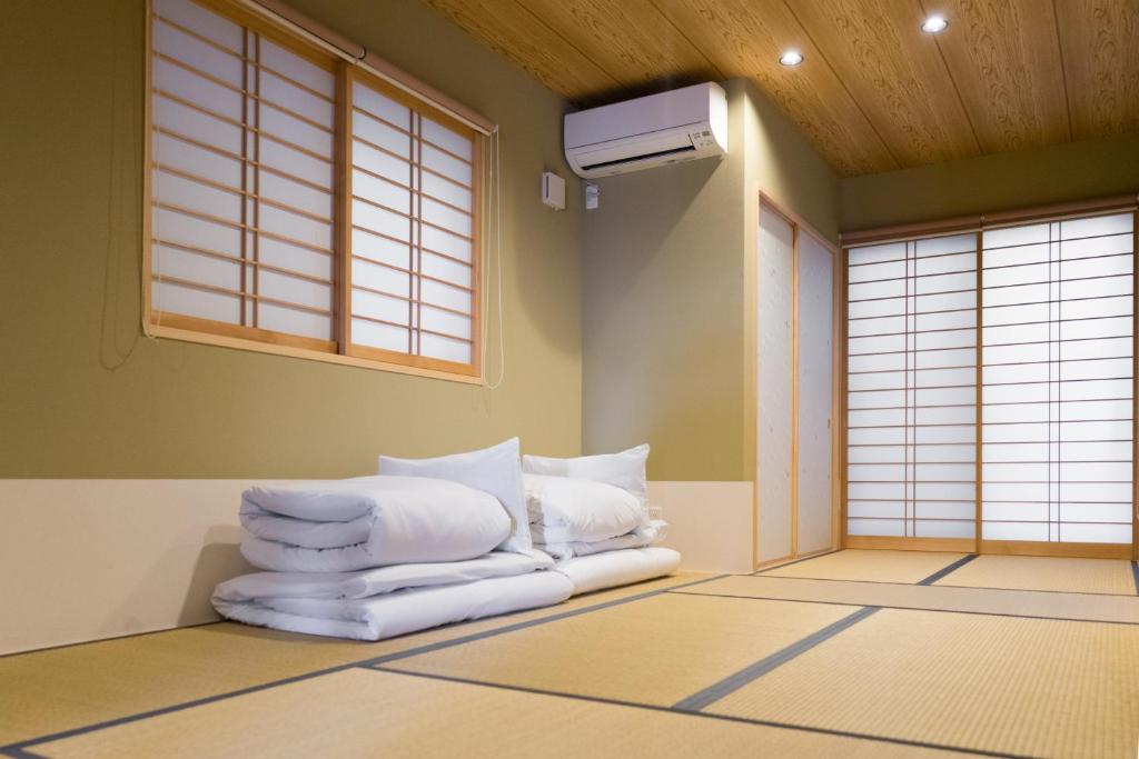 a room with a pile of towels on the floor at Guesthouse ZenNichi in Kyoto