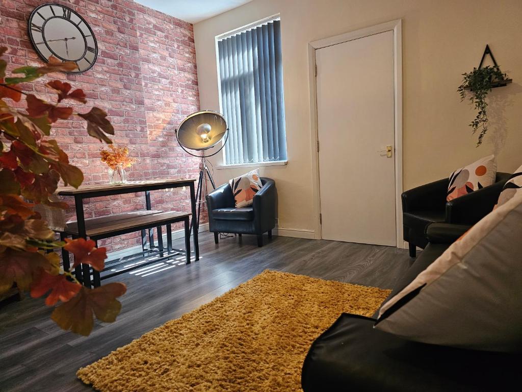 uma sala de estar com uma parede de tijolos em Fife House - Welcome Short Stays em Derby