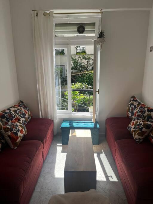 - un salon avec deux canapés rouges et une fenêtre dans l'établissement Cosy renovated 1-bedroom Etoile, à Paris