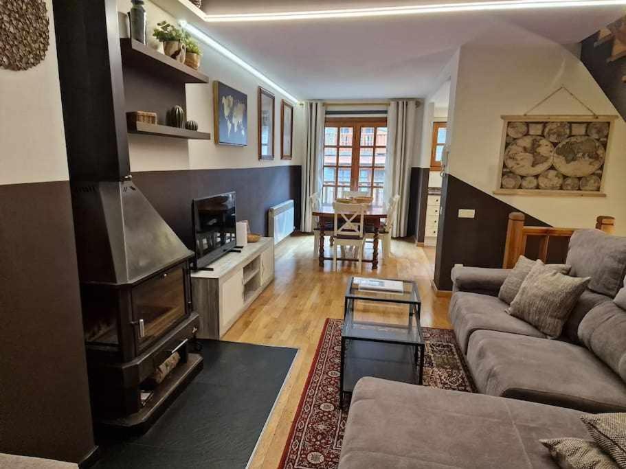 a living room with a couch and a fireplace at Ático acogedor centro de Canillo in Canillo