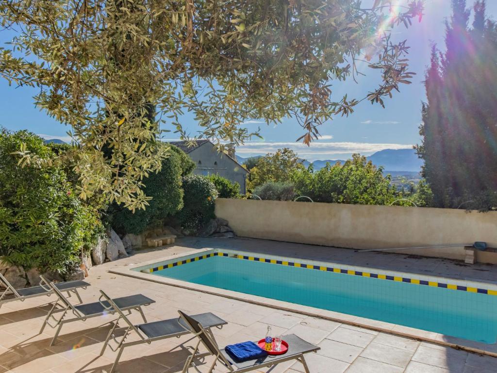 - une piscine dans un jardin avec des chaises et une table dans l'établissement Holiday Home Lumière by Interhome, à Vinsobres