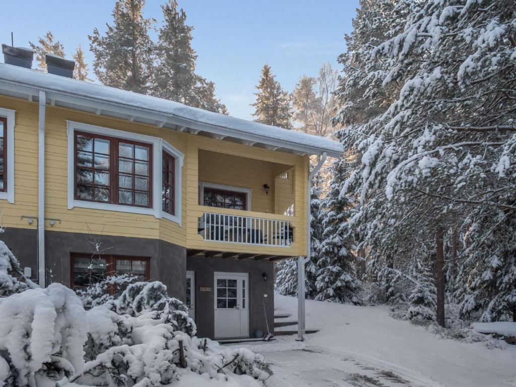 LahdenperäにあるHoliday Home Vaarapirtti - tähti by Interhomeの雪の中のバルコニー付きの黄色い家