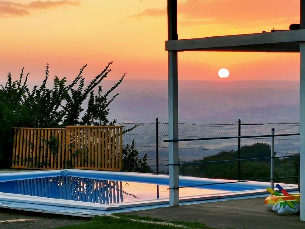 una piscina con tramonto sullo sfondo di Casa vacanze Guardea a Guardea