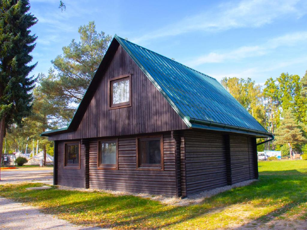 una pequeña casa de madera con techo de estaño en Holiday Home Kemp Stříbrný rybník-1 by Interhome en Hradec Králové