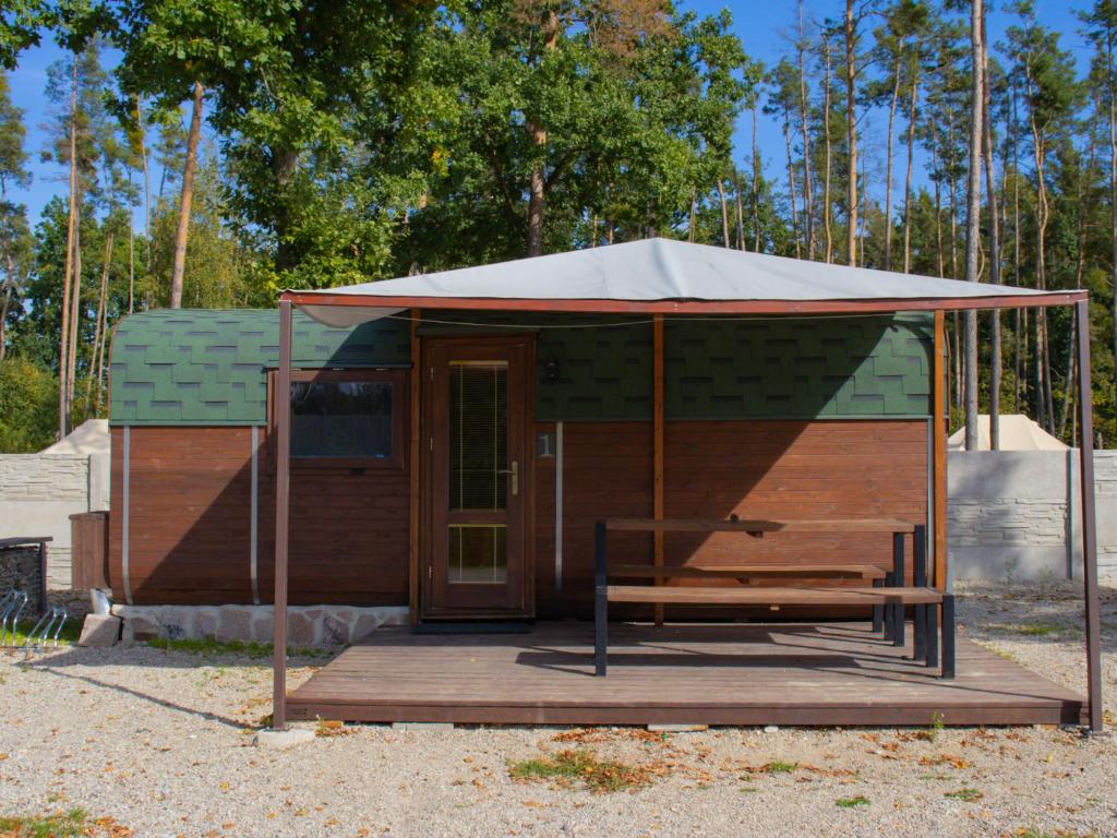 eine kleine Hütte mit einem Baldachin auf einer Holzterrasse in der Unterkunft Holiday Home Kemp Stříbrný rybník-1 by Interhome in Hradec Králové