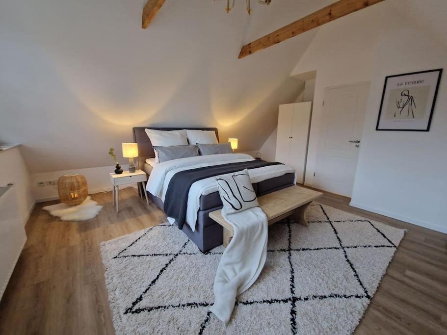 ein Schlafzimmer mit einem großen Bett und einem Teppich in der Unterkunft Voll ausgestattetes 2 Zimmer Apartment Sanssouci in Osnabrück