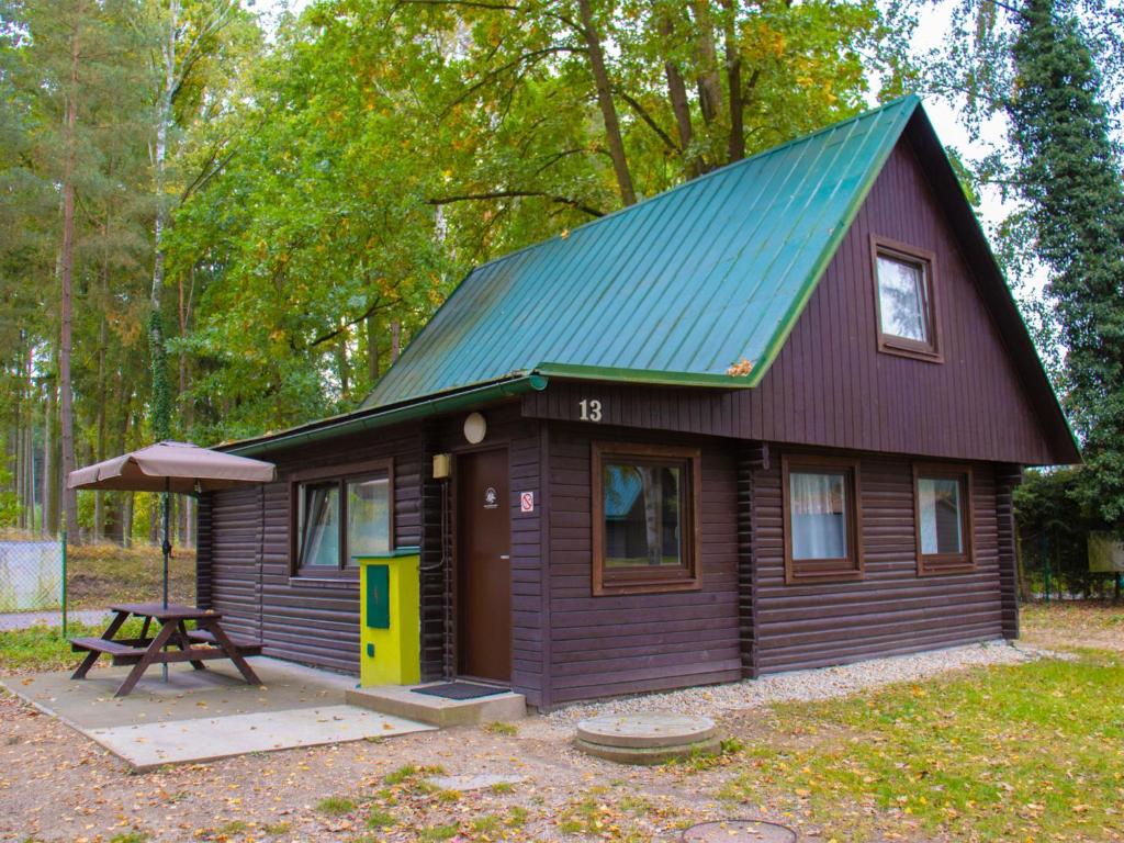 eine kleine Hütte mit einem Picknicktisch davor in der Unterkunft Holiday Home Kemp Stříbrný rybník-13 by Interhome in Hradec Králové