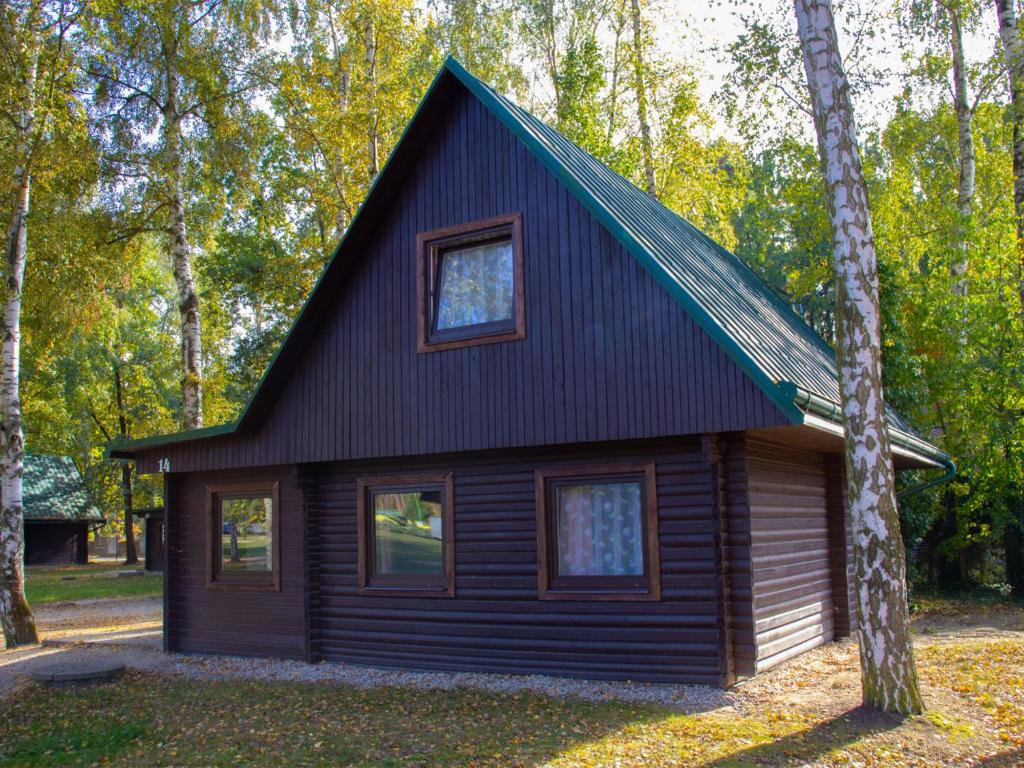 a small cabin in the woods with a green roof at Holiday Home Kemp Stříbrný rybník-14 by Interhome in Hradec Králové