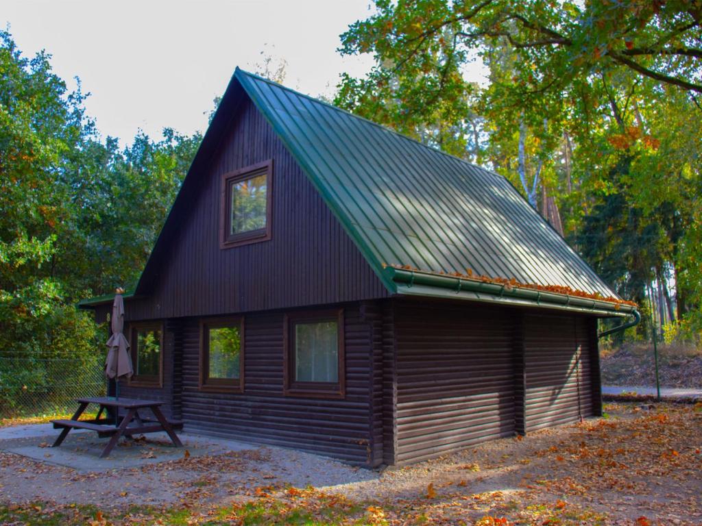 a small cabin with a picnic table in front of it at Holiday Home Kemp Stříbrný rybník-8 by Interhome in Hradec Králové