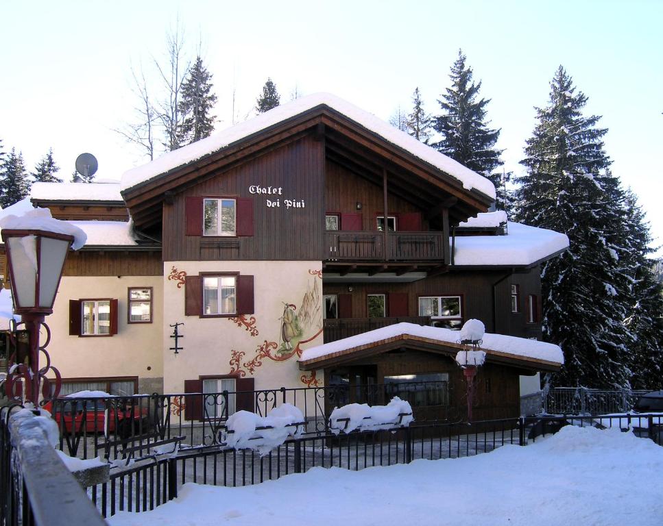 a large building with snow on the front of it at Chalet dei Pini in Madonna di Campiglio