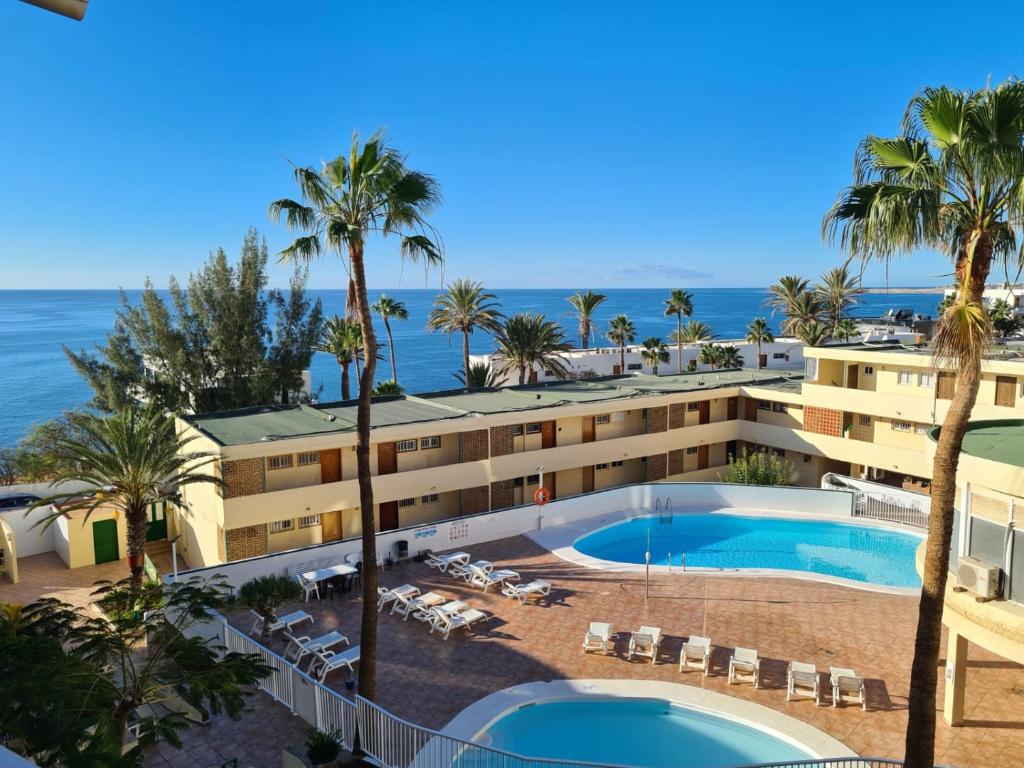 een luchtzicht op een hotel met een zwembad en de oceaan bij SEAVIEW APARTMENT LA COLINA in San Agustin