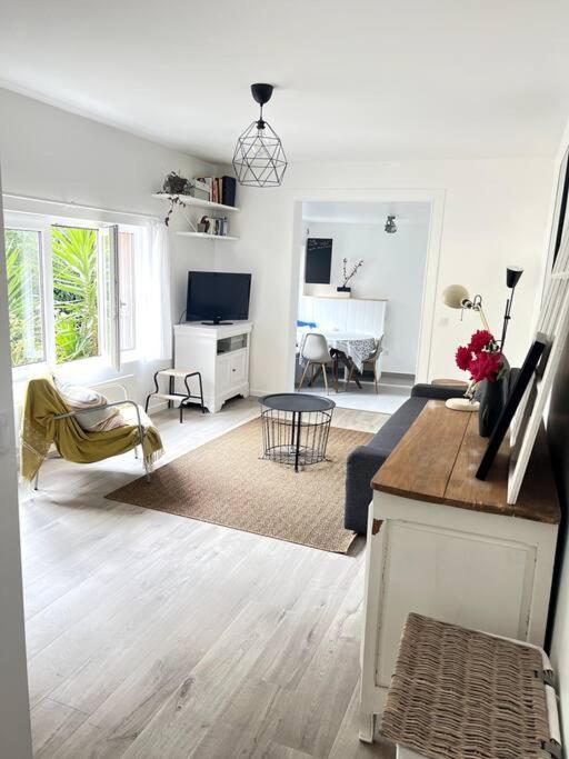 - un salon blanc avec un canapé et un piano dans l'établissement Le Rocher Trouville, à Trouville-sur-Mer