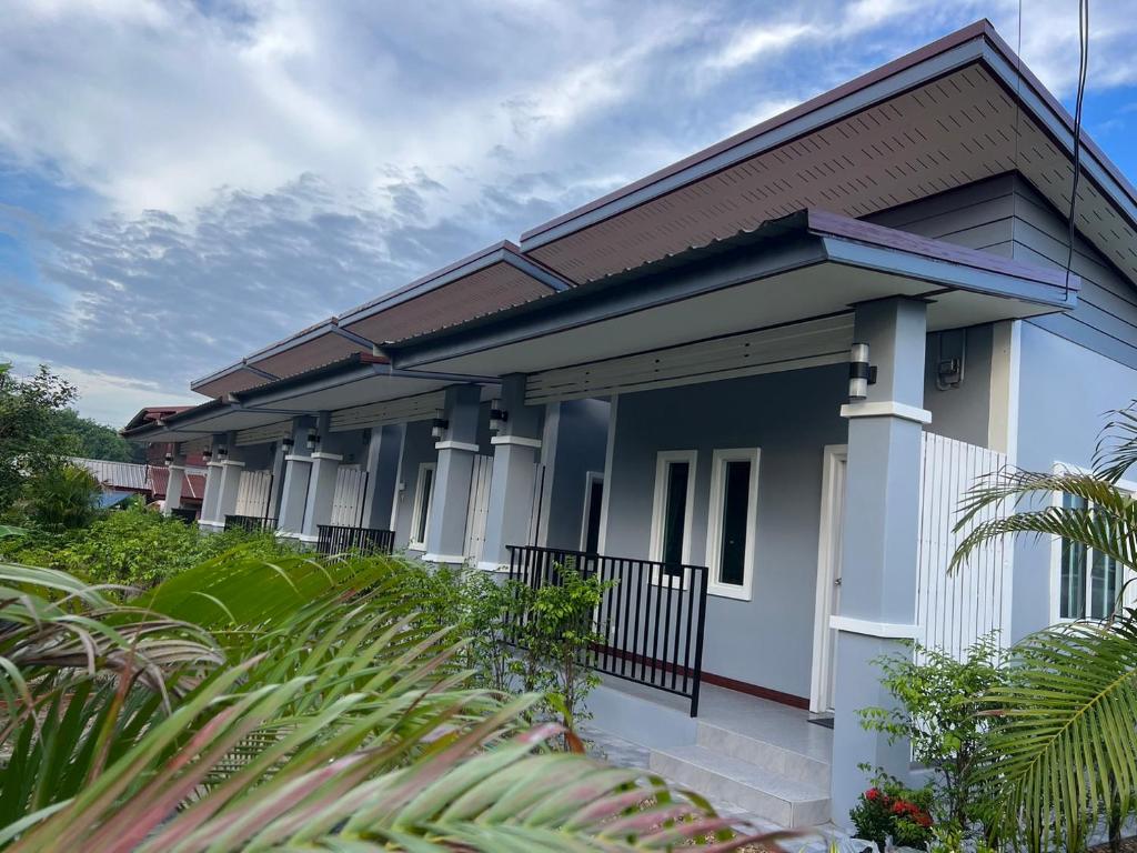 una casa con facciata blu e bianca di KP House Bueng Kan a Seka