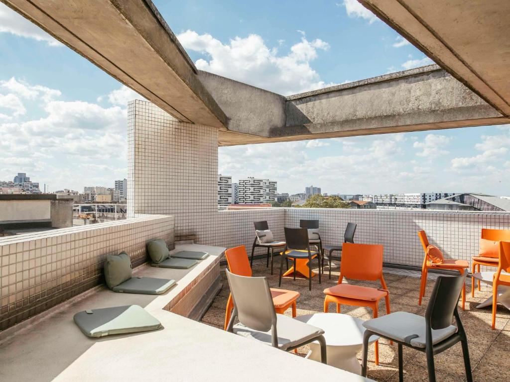 d'une terrasse sur le toit avec des chaises et des tables. dans l'établissement Aparthotel Adagio Access Paris La Villette, à Paris