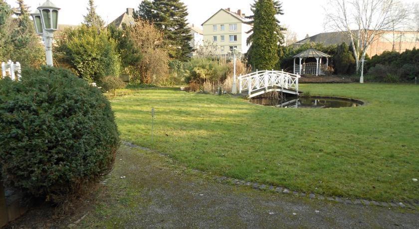 a yard with a white bridge in the grass at Hotel Specht in Witten