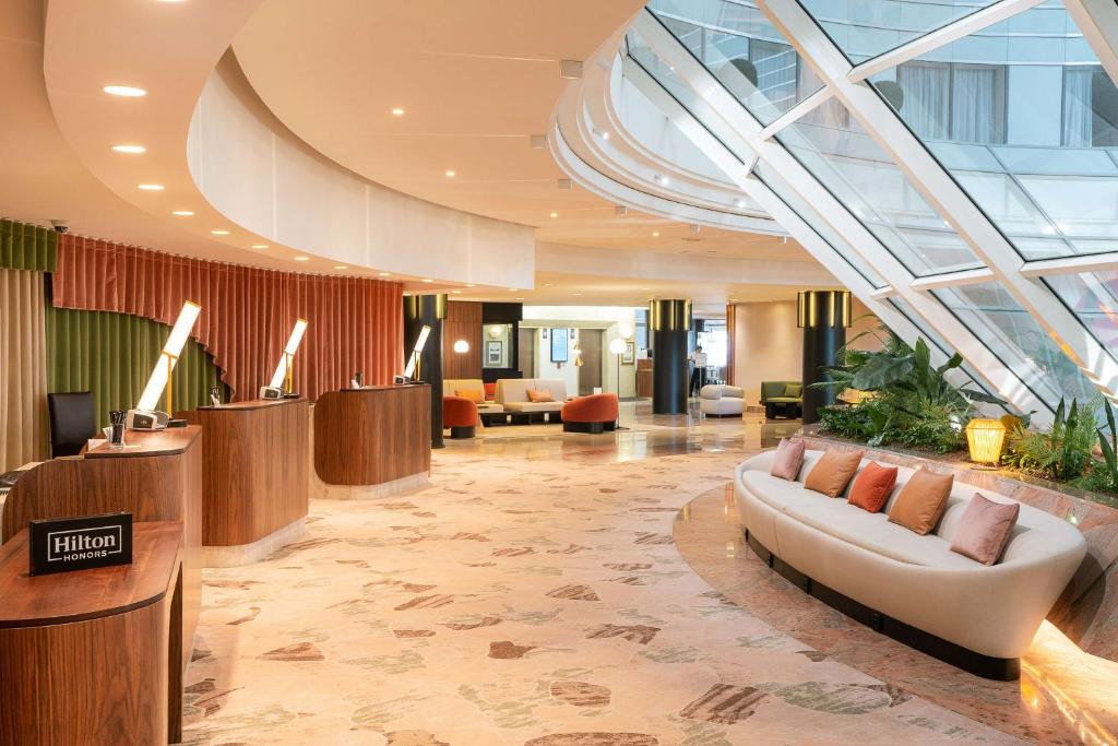 a lobby with a couch in the middle of a building at Hilton Paris La Défense in Puteaux