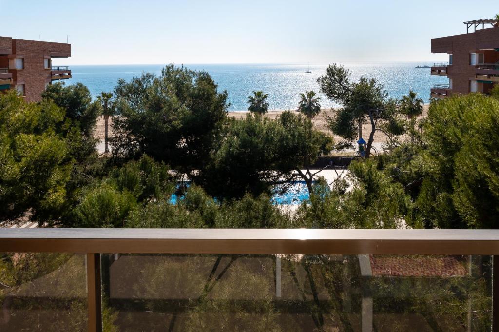 a view of the beach from the balcony of a resort at AT049 Els Pins, primera línea de la playa con piscina y barbacoa in Torredembarra