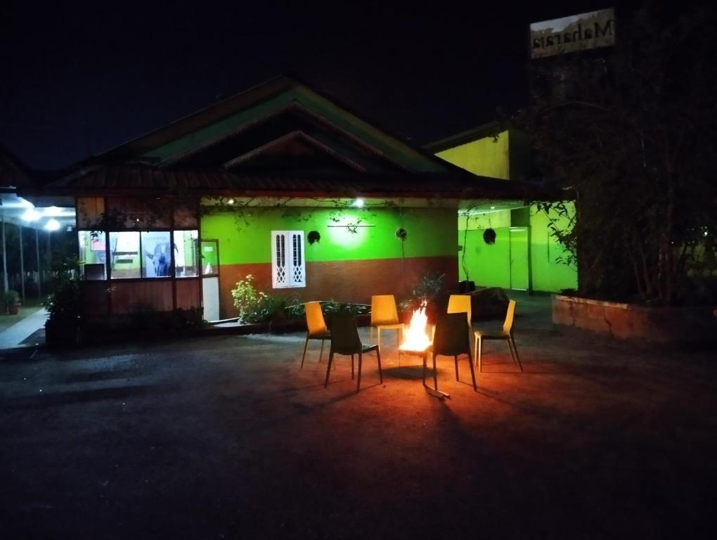 einen Tisch und Stühle vor einem Gebäude in der Nacht in der Unterkunft Maharaja Cottage in Munnar