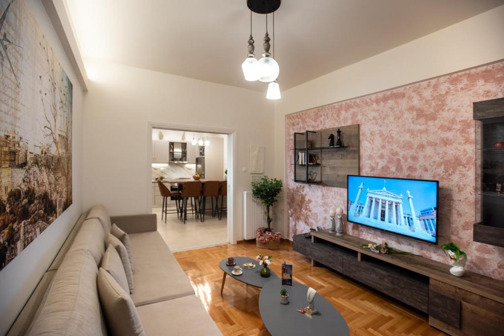ein Wohnzimmer mit einem Sofa und einem TV an der Wand in der Unterkunft Blue Ark Acropolis Compass in Athen
