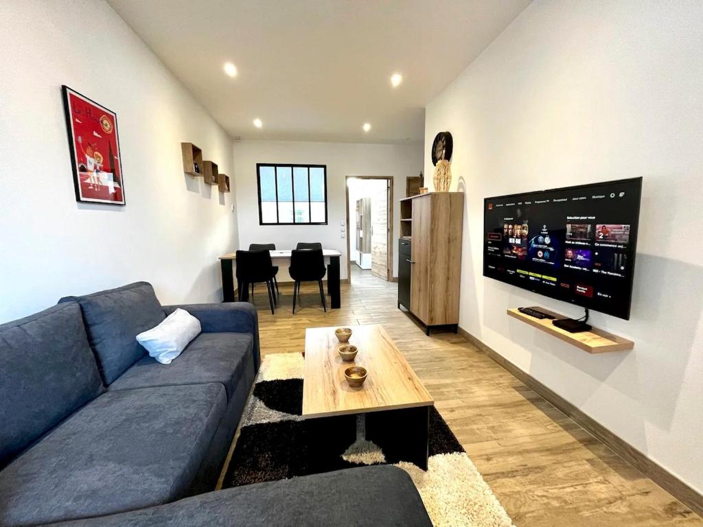 a living room with a blue couch and a tv at Appartement Louise in Le Havre