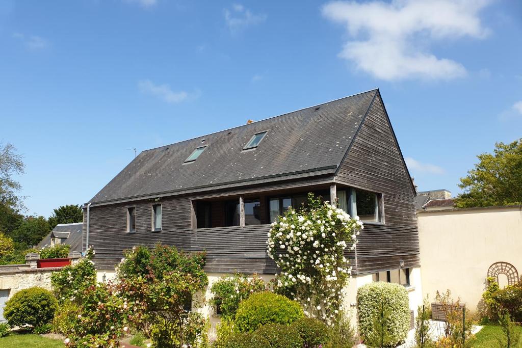 une maison avec un toit noir dans l'établissement Villa Bayeusaine, maison Bayeux Centre Historique - 3 chambres, à Bayeux