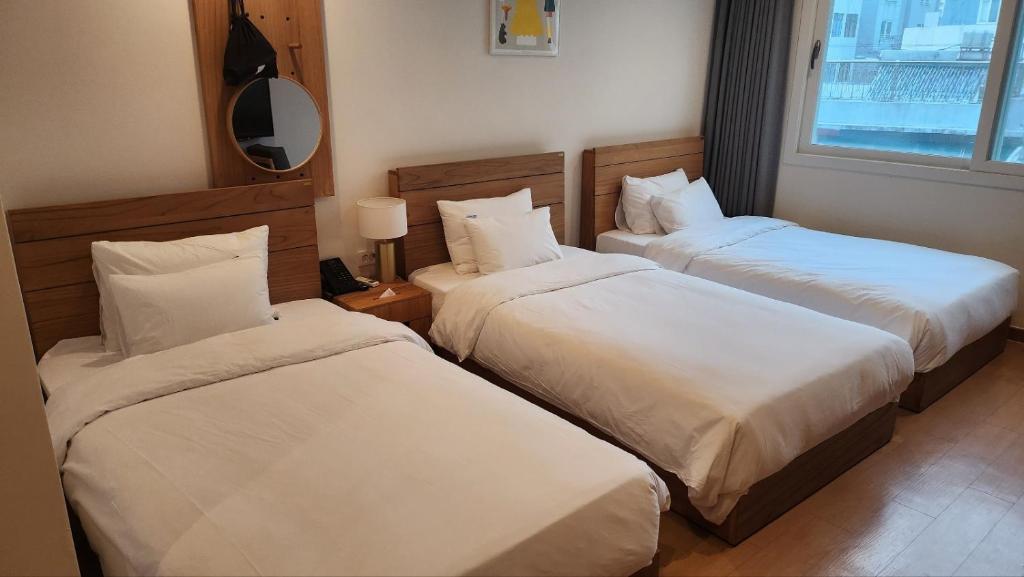 Postel nebo postele na pokoji v ubytování Heyy Seogwipo Hotel
