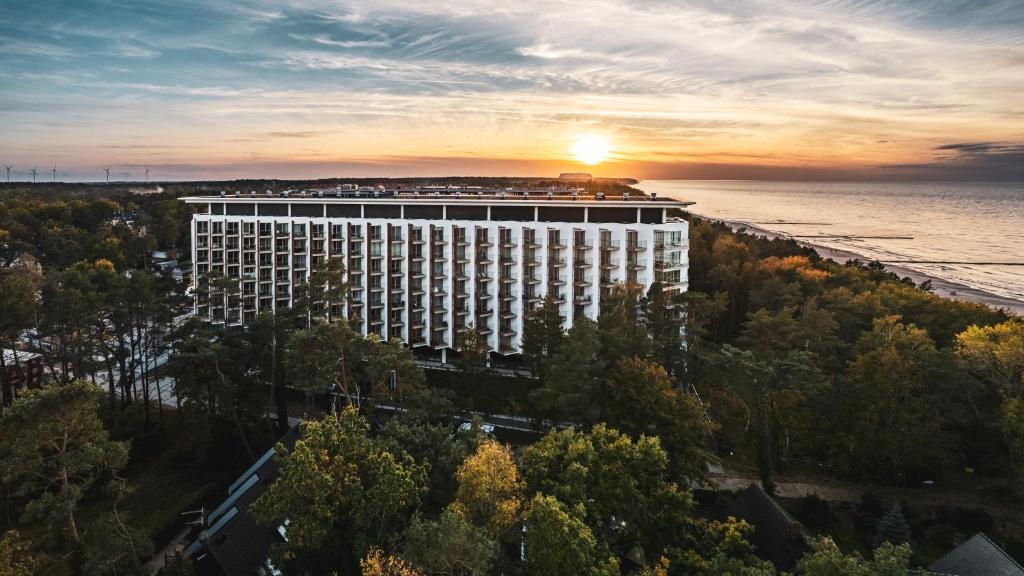 an aerial view of a building with the sunset in the background at Pinea, Sun & Snow in Pobierowo