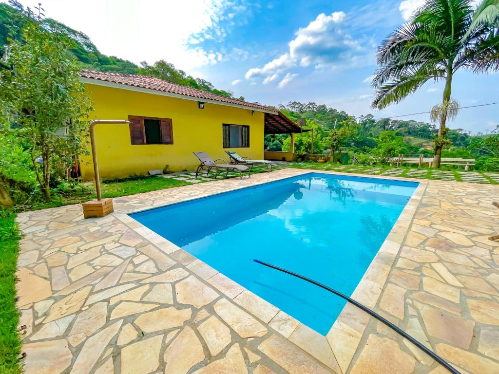 a villa with a swimming pool and a house at Espaço Céu Azul in Nazaré Paulista