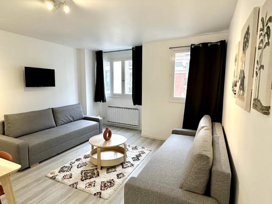 un salon avec un canapé et une table dans l'établissement Stade de France 8min - Idéal JO 2024, à Saint-Denis