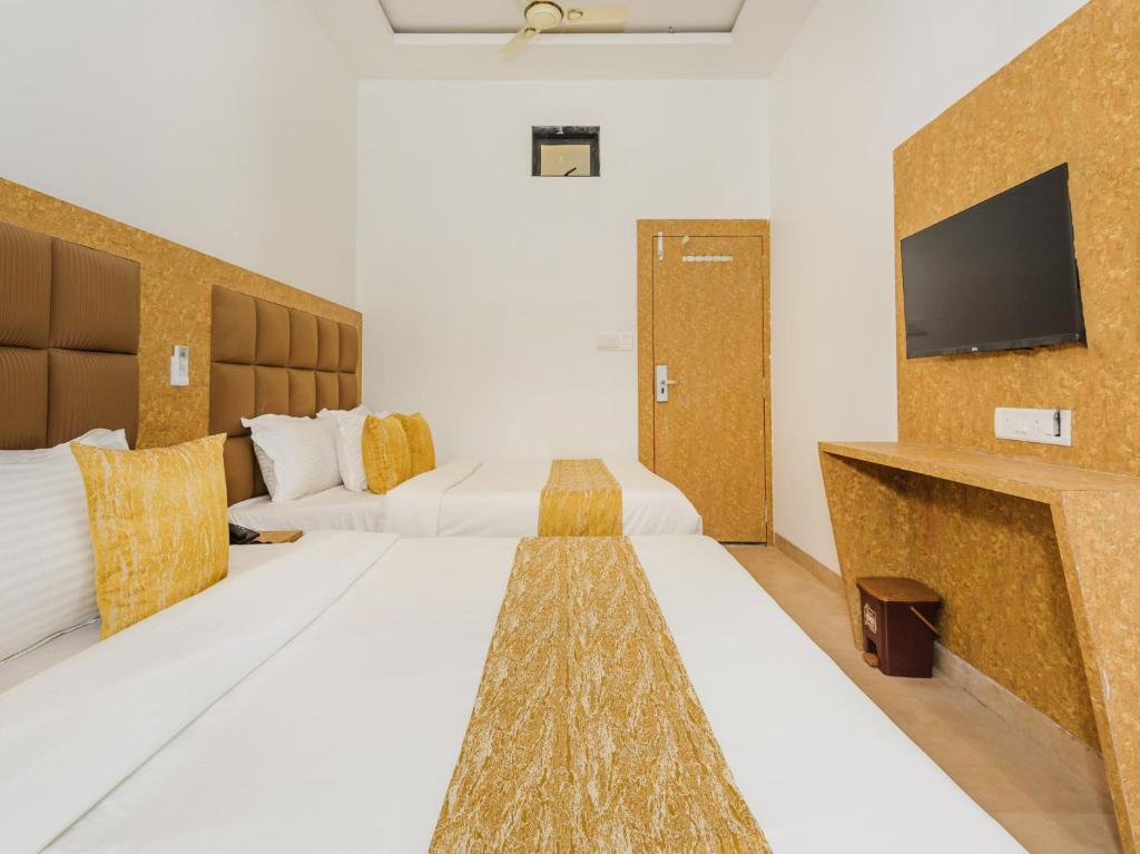 een hotelkamer met 2 bedden en een flatscreen-tv bij Hotel Zillion Executive - Kurla West Mumbai in Mumbai