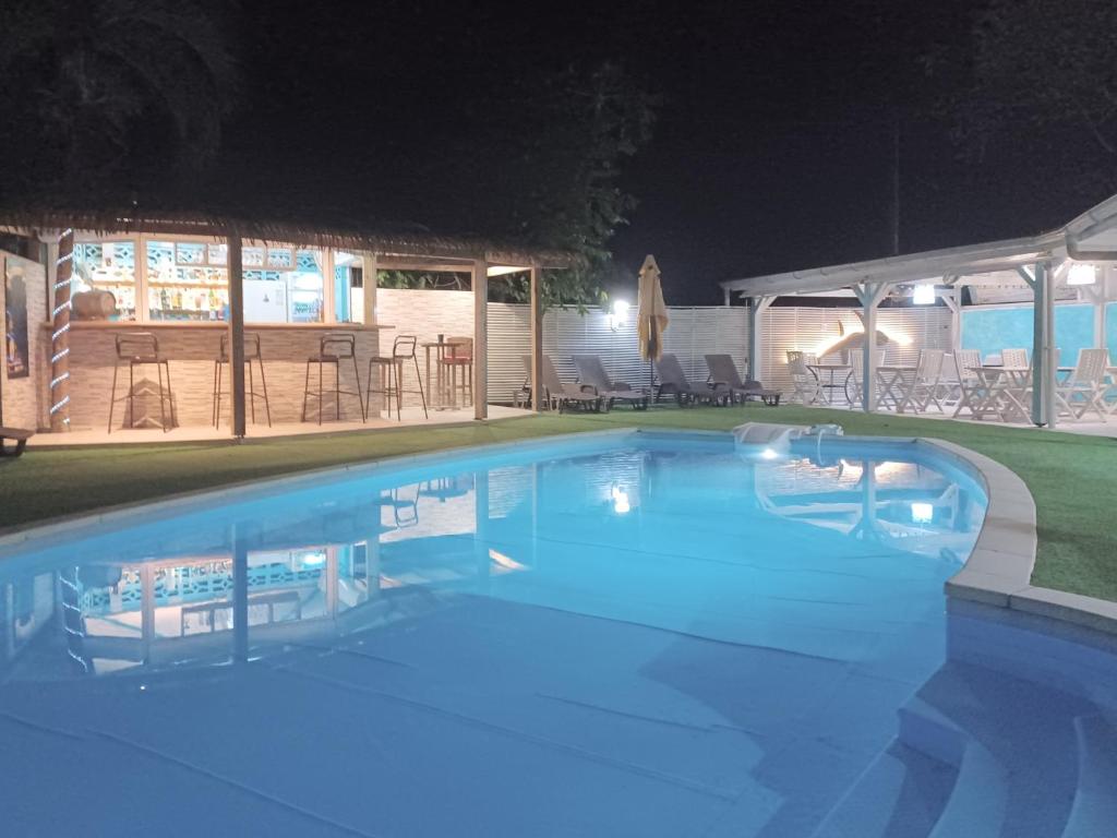 a swimming pool with blue water at night at La Rose du Bresil Marie-Galante in Capesterre