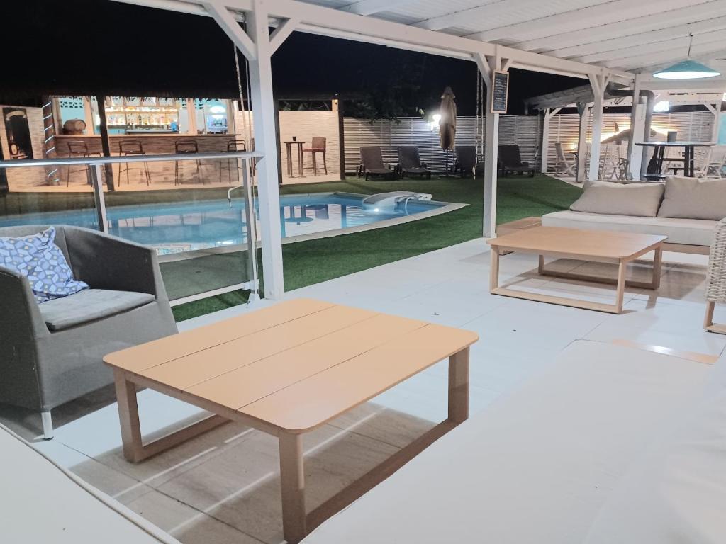 a living room with a table and a pool at La Rose du Bresil Marie-Galante in Capesterre