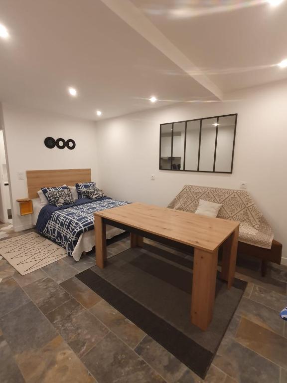 une chambre avec un lit et une table en bois dans l'établissement Beau studio moderne proche de CDG/Paris/Parc d'Expo, à Aulnay-sous-Bois