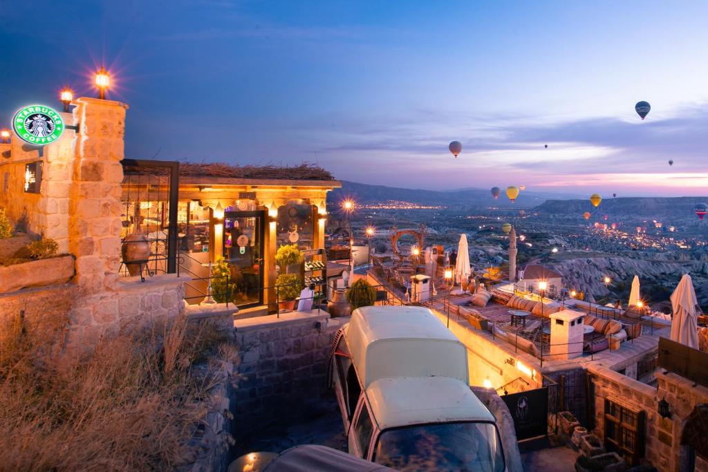 Blick auf eine Stadt in der Nacht mit Heißluftballons in der Unterkunft Dream of Cappadocia in Uchisar