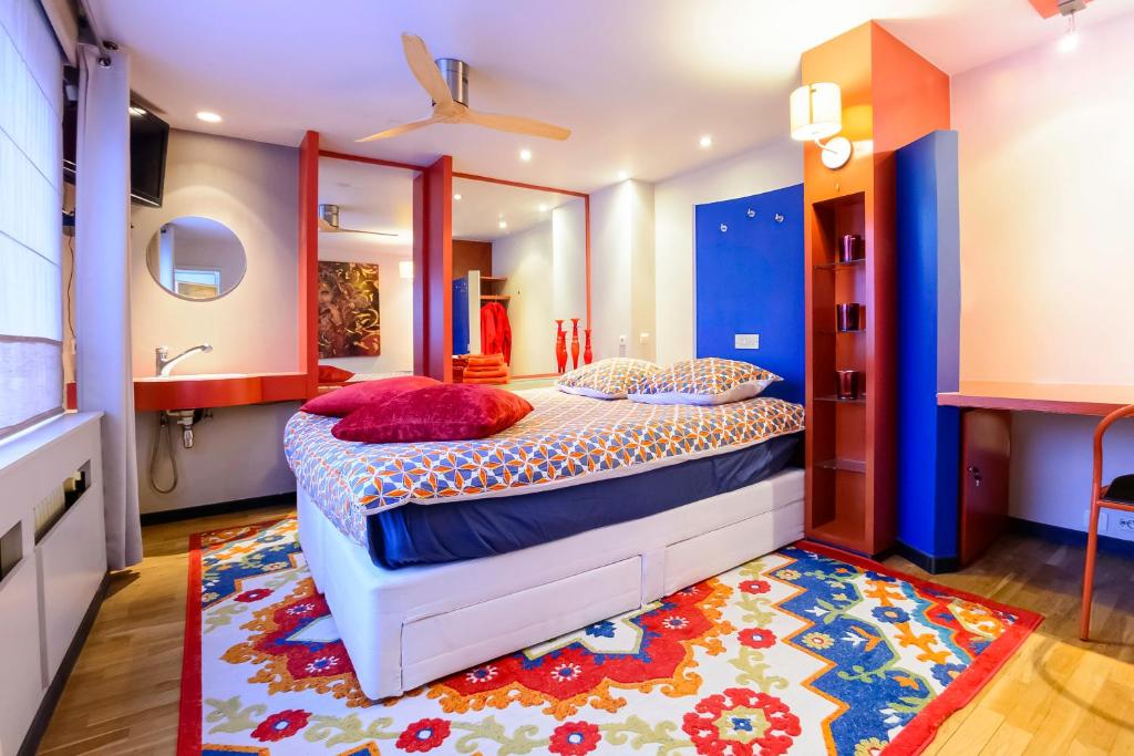 a bedroom with a large bed and a rug at BeautyD RED ROOM centrum Gullegem in Wevelgem