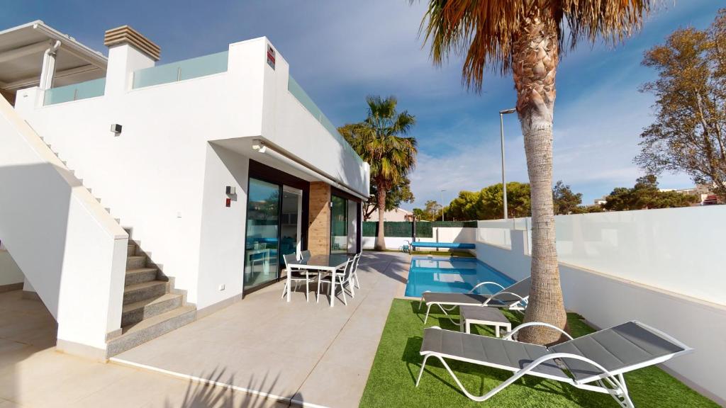 a white house with a swimming pool and a patio at Holidoo Travel "Villa Deluxe" in Los Alcázares