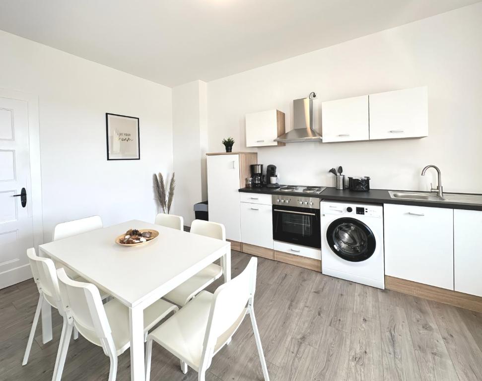 eine Küche und ein Esszimmer mit einem weißen Tisch und Stühlen in der Unterkunft Monteurwohnung mit Balkon in Hattingen