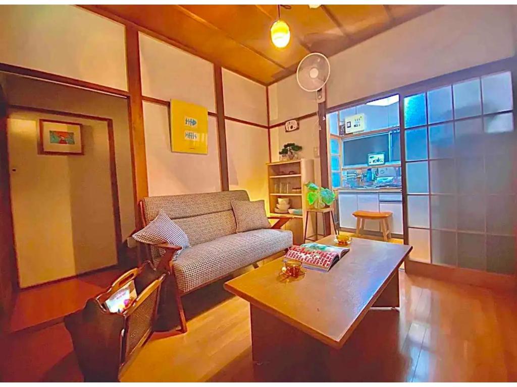 uma sala de estar com um sofá e uma mesa de centro em KAMEYA HOUSE ENOSHIMA - Vacation STAY 69765v em Fujisawa
