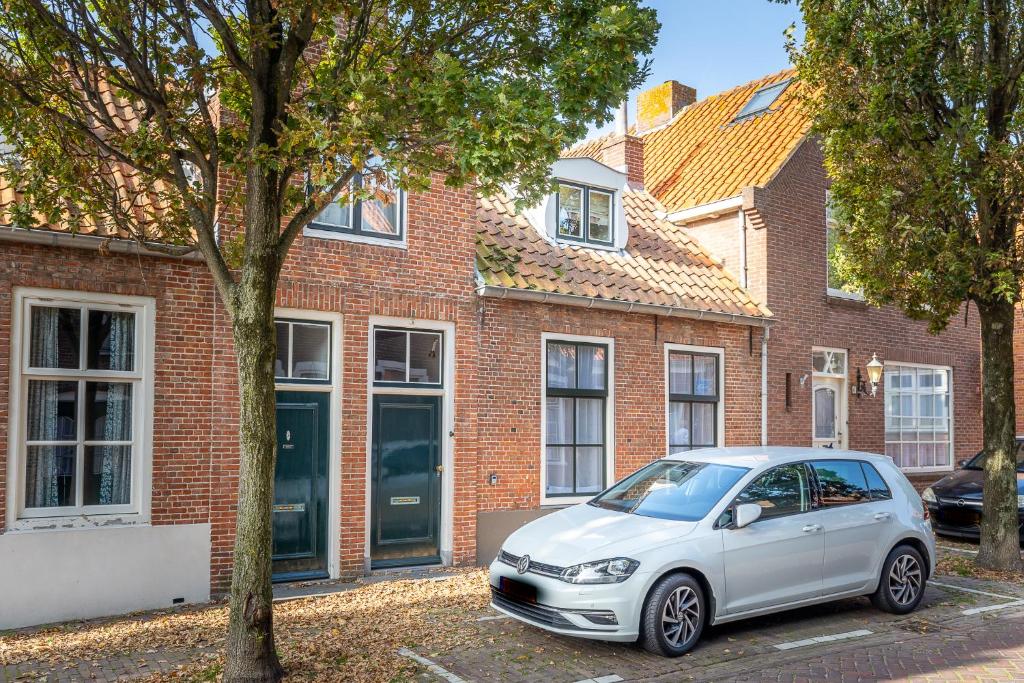a white car parked in front of a brick building at Ruime woning in het centrum van Domburg in Domburg