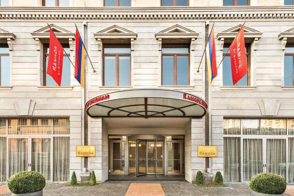 a building with flags in front of it at Ramada Hotel & Suites by Wyndham Yerevan in Yerevan