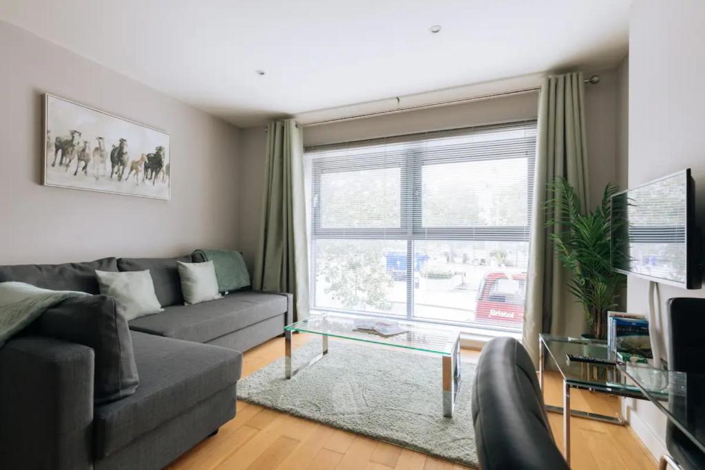a living room with a couch and a window at Contemporary 1BD Flat - Bristol City Centre! in Bristol
