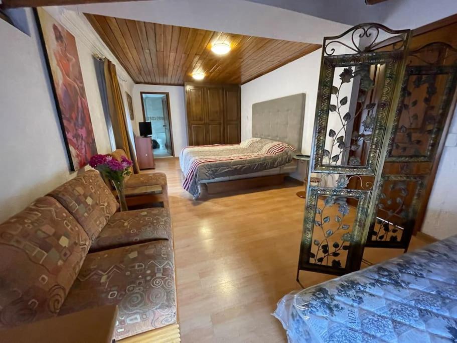 uma sala de estar com um sofá e uma cama em Casa hermosa, amplia y elegante em Quito