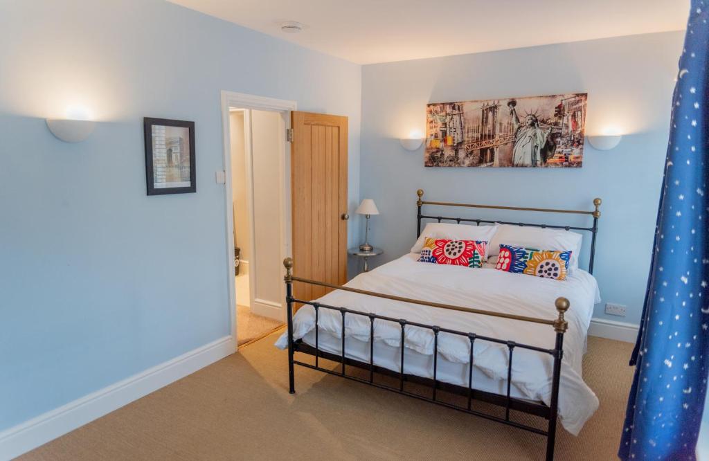 1 dormitorio con 1 cama y una pintura en la pared en Stunning period cottage en Wrington