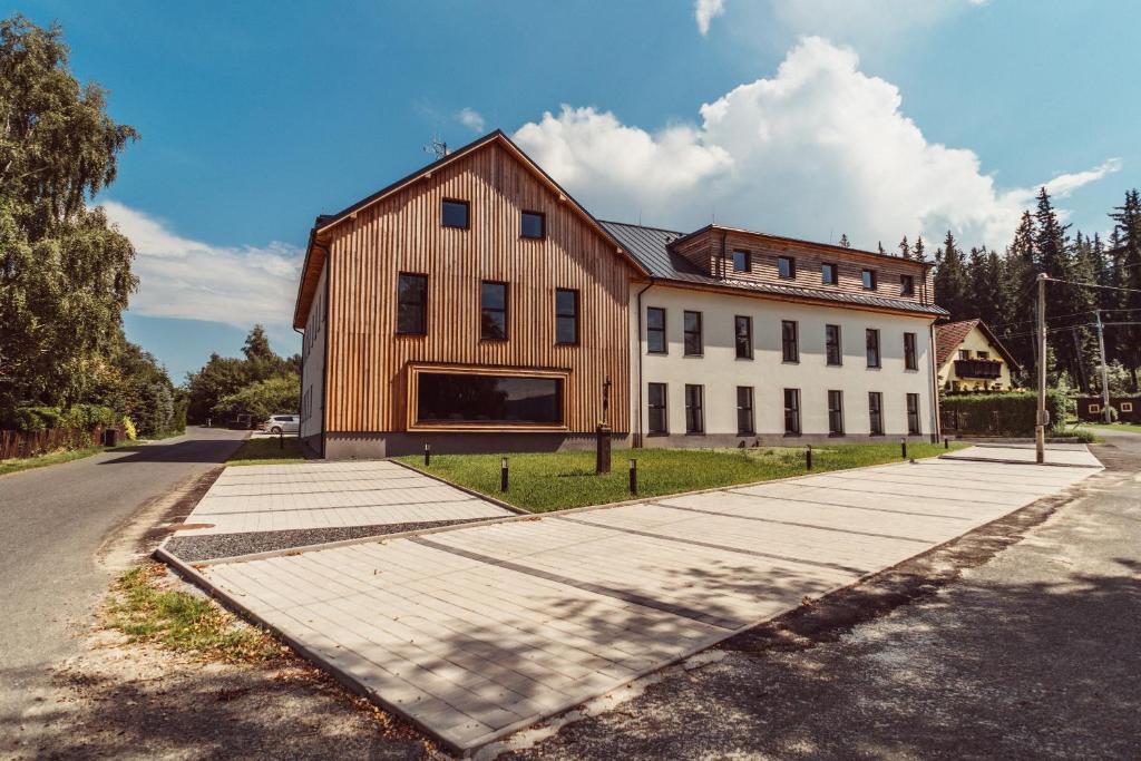 a large wooden building on the side of a road at Apartmány Javorná in Čachrov